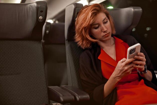 A traveler happily reclining in a fully reclined airline seat in business class, using a laptop and wearing noise-canceling headphones. The cabin appears spacious and comfortable, with personalized service from the flight attendant visible in the background.