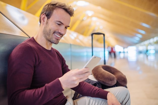 A person smiling and holding airline tickets and a passport, sitting at an airport gate, conveying excitement about an upcoming trip made possible by airline miles.