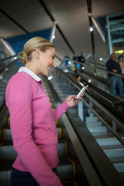 A person happily looking at a smartphone displaying their airline miles balance, with a background showing a blurred image of an airport terminal.