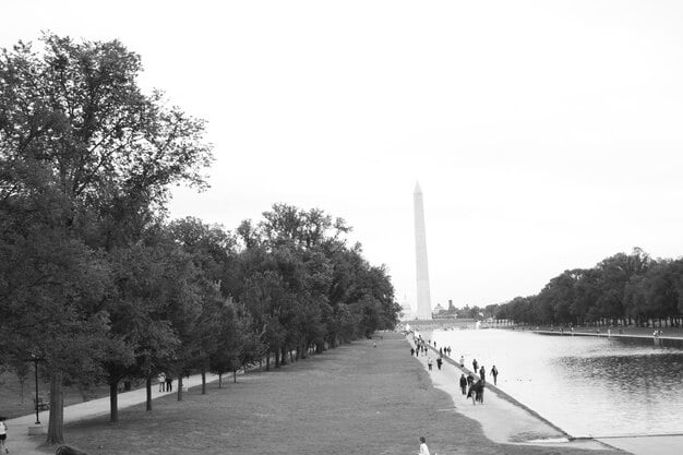 A black-and-white photograph of the Lincoln Memorial in Washington D.C., with the statue of Abraham Lincoln prominently displayed and visitors admiring the monument.