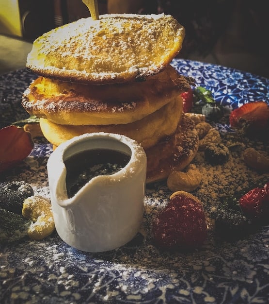 A vibrant overhead shot of a table filled with New Orleans culinary classics: jambalaya, gumbo, beignets with powdered sugar, and a steaming cup of cafe au lait.