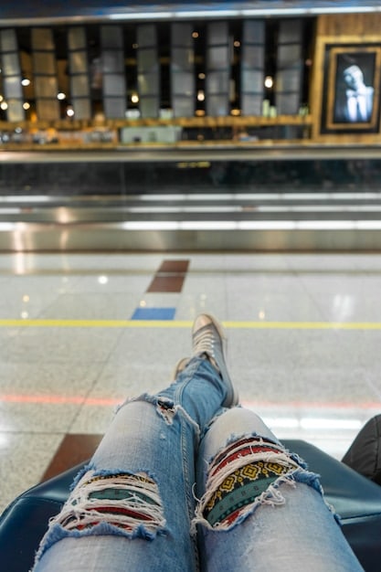 A close-up shot of a traveler's feet wearing slip-on shoes and colorful socks, standing on the sanitized floor of an airport security checkpoint.