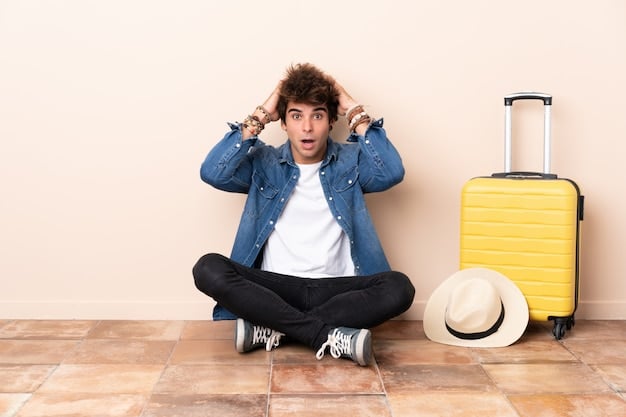 A traveler looking stressed and holding their head while sitting on a suitcase in an airport, with a canceled flight notification displayed on a nearby screen, emphasizing the need for travel insurance.