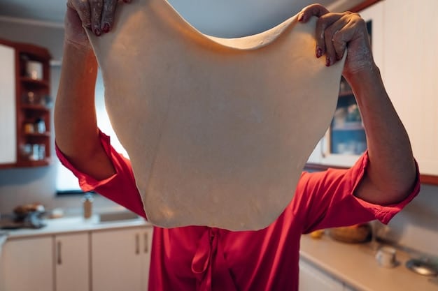 A close-up demonstrating the folding process of a t-shirt before rolling. The t-shirt is laid flat, and one side is being folded over to the middle. Hands are shown smoothing out the fabric to eliminate wrinkles.