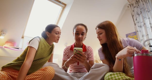 Inside a vibrant hostel common room, a group of international students are laughing and talking while sitting on colorful couches.