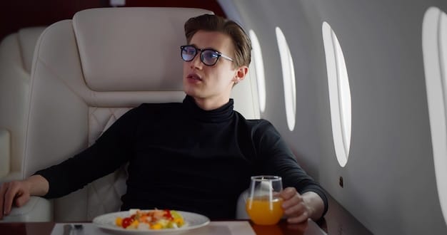 A person sitting comfortably in a first-class airplane seat, enjoying a meal and the spacious surroundings.