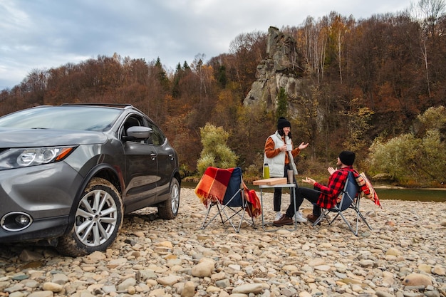 A family car packed with camping gear parked at a scenic overlook in a national park. Focus on the 