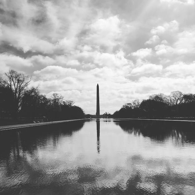 A black and white photograph of the Lincoln Memorial in Washington D.C., reflecting in the pool in front of it. A few visitors are silhouetted against the bright marble, emphasizing the monument's grandeur and solemnity.