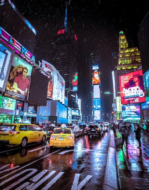 A vibrant photo of Times Square in New York City at night, with its bright lights, bustling crowds, and iconic billboards, capturing the essence of urban energy and the excitement of city life and the keyword 