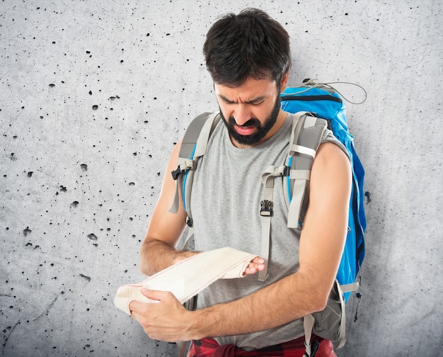 A person rock climbing with travel insurance documents visible in their backpack, highlighting the importance of checking exclusions for adventurous activities. It subtly relates to Avoid These 5 Common Travel Insurance Traps That Cost Americans Thousands.