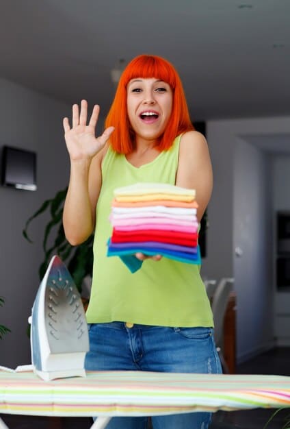 A person demonstrating the rolling technique on a bright-colored t-shirt. They are on a clean, organized surface, and the focus is on their hands as they roll the shirt tightly. This visual emphasizes the space-saving benefits of rolling clothes when you want to Maximize Your Carry-On: Pack 7 Days of Clothes.