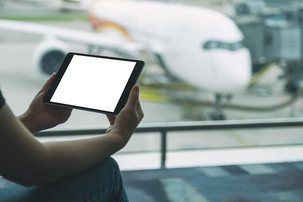 A hand holding up a credit card with an airplane icon, positioned over a blurred background of a flight booking website on a tablet.